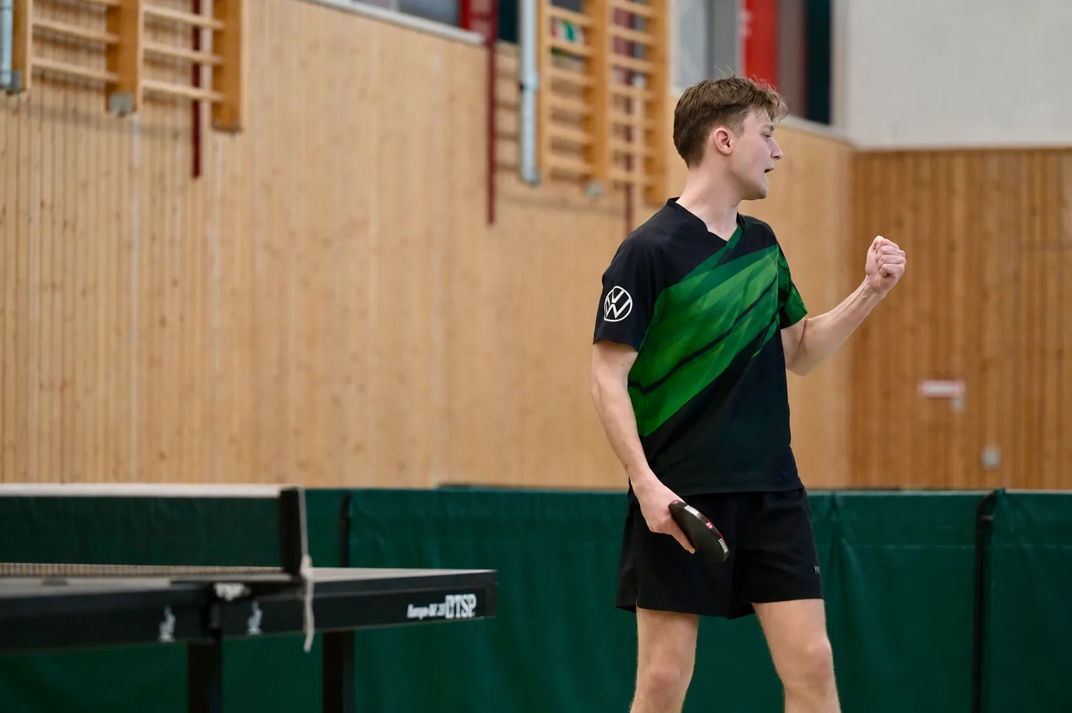 Tischtennisspieler freut sich über seinen Erfolg, den er erlangt durch seinen neuen Trainer, den er bei www.coazio.com gefunden hat.